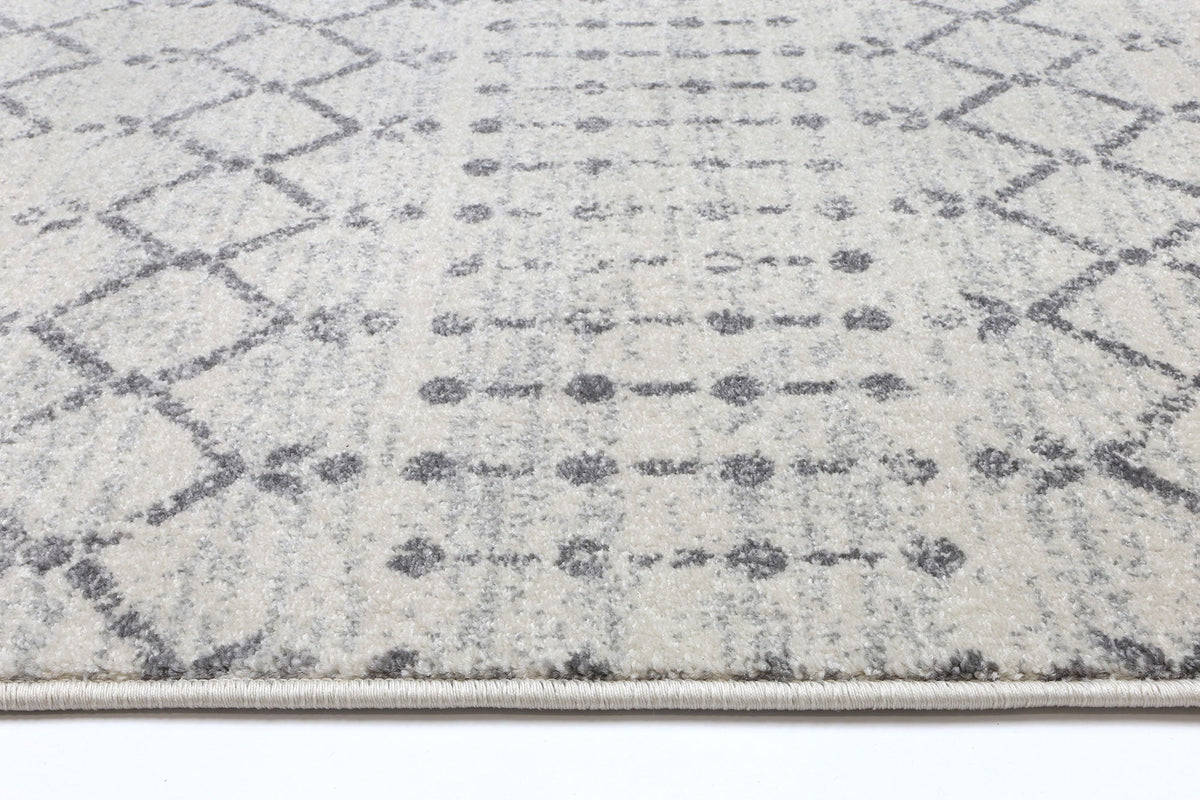 Le Canvas Elowen — Ivory and grey geometric rug, corner and bound-edge detail