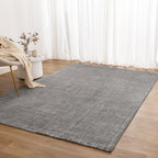 Le Canvas Marlow — Grey rug styled beside a soft-neutral armchair