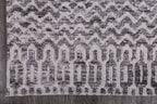 Le Canvas Kira — Grey tribal-geometric rug, corner and bound-edge detail on timber floor