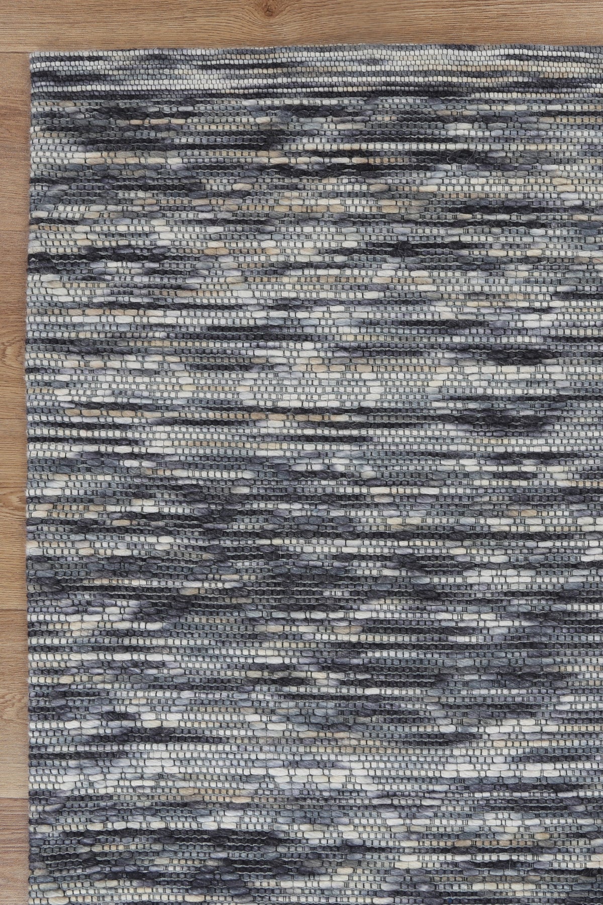 Le Canvas Pilar — Stone diamond rug, corner and bound-edge detail on timber floor