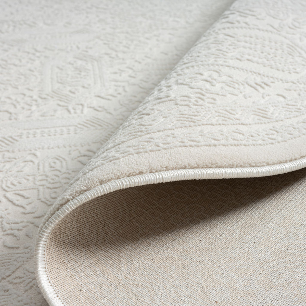 Le Canvas Eira — Ivory round rug, reverse and construction